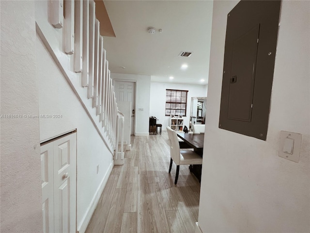 hallway featuring light wood-type flooring and electric panel