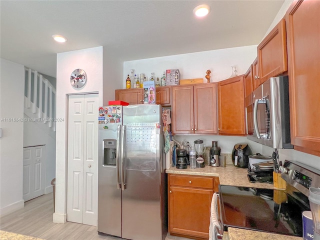 kitchen featuring appliances with stainless steel finishes and light hardwood / wood-style floors