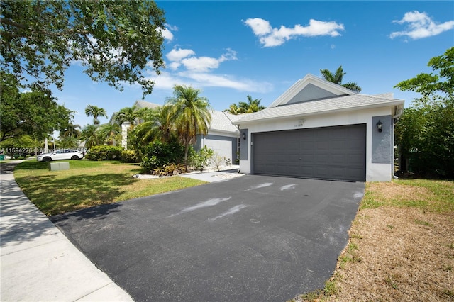 ranch-style home featuring a garage and a front lawn