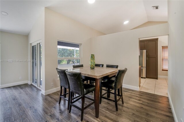 dining room featuring hardwood / wood-style flooring and vaulted ceiling