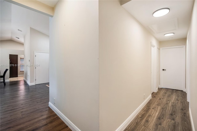 hall featuring dark hardwood / wood-style floors and vaulted ceiling