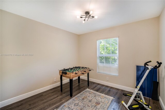 rec room featuring dark hardwood / wood-style flooring and a chandelier