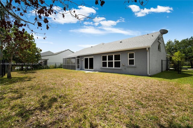 rear view of house featuring a lawn