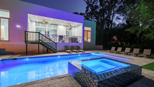 pool at night featuring a patio area, an in ground hot tub, and ceiling fan