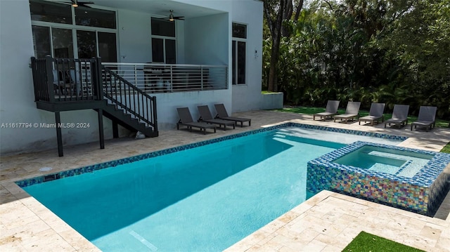 view of swimming pool with ceiling fan, a patio, and an in ground hot tub