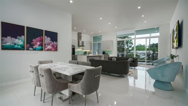 dining space featuring sink, light tile patterned flooring, and floor to ceiling windows