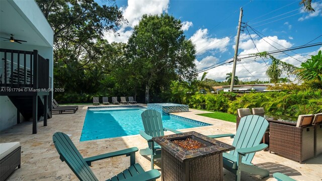 view of pool featuring ceiling fan, an outdoor fire pit, an in ground hot tub, and a patio