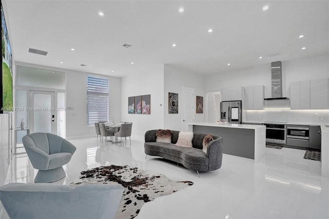 living room with light tile patterned floors and floor to ceiling windows