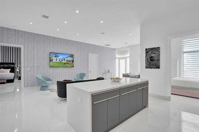 kitchen featuring a center island, gray cabinetry, and light tile patterned floors