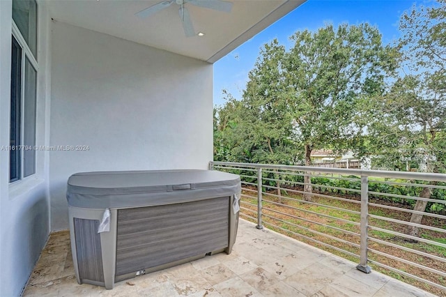 view of patio / terrace featuring ceiling fan, a balcony, and a hot tub