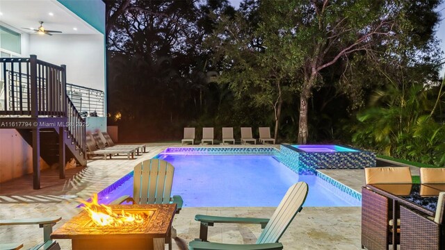 view of pool featuring an in ground hot tub, a patio, ceiling fan, and a fire pit