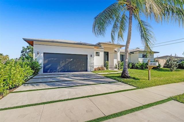 view of front of property with a garage and a front lawn