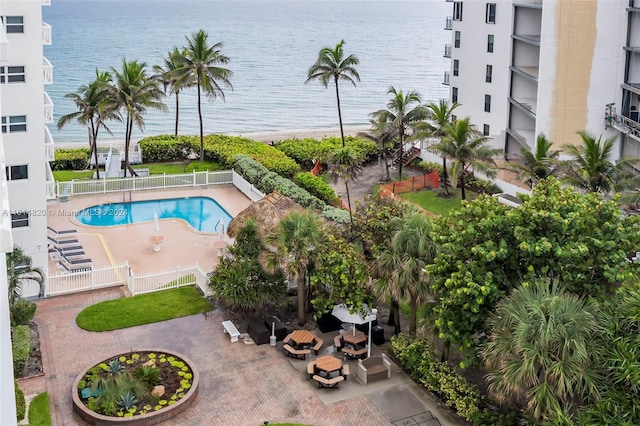 view of pool featuring a water view and a patio