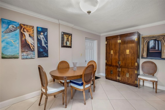 tiled dining space featuring ornamental molding and a textured ceiling