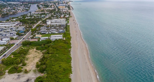 birds eye view of property with a water view and a beach view