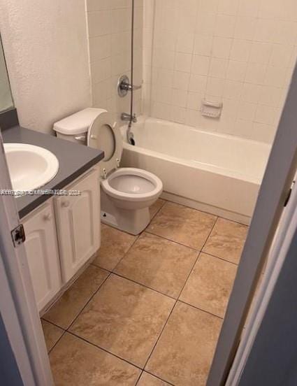 full bathroom with vanity, tiled shower / bath, tile patterned flooring, and toilet