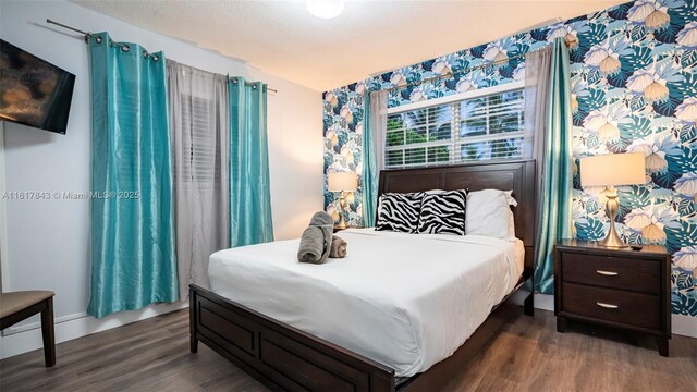 bedroom featuring dark hardwood / wood-style flooring and a textured ceiling