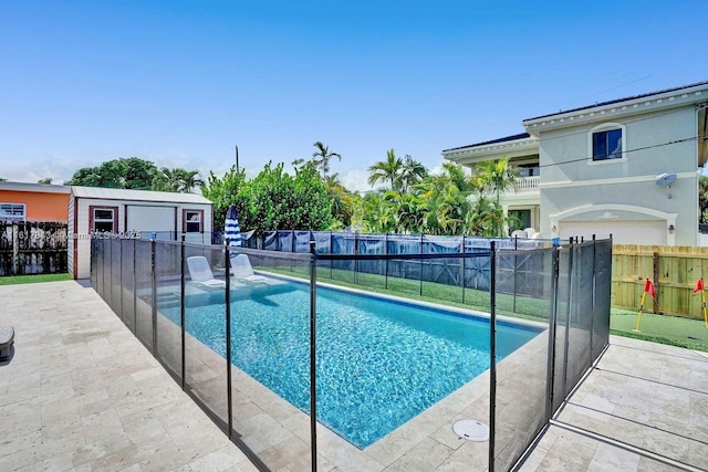 view of swimming pool with an outdoor structure and a patio area