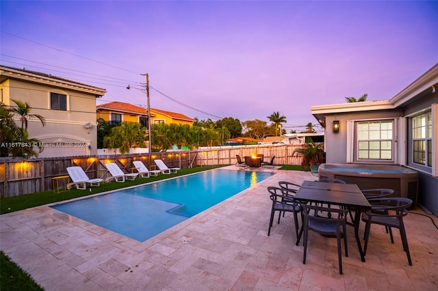 pool at dusk with a patio area