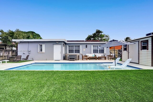 rear view of house featuring a yard and outdoor lounge area