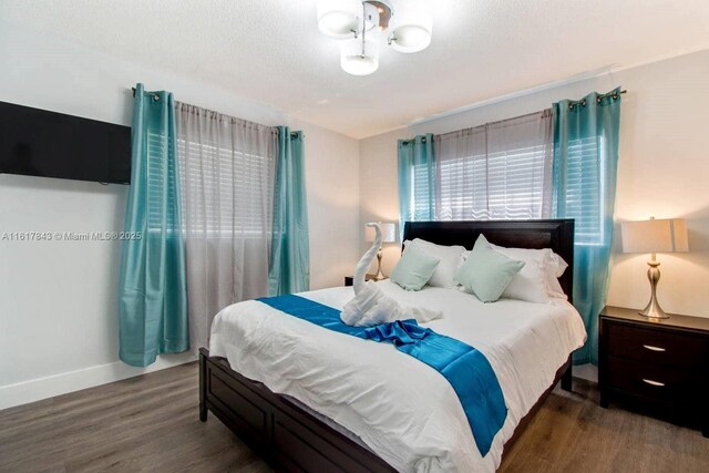 bedroom featuring dark hardwood / wood-style flooring and a textured ceiling