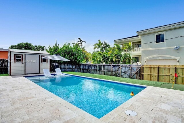 view of swimming pool with a patio area and a storage shed