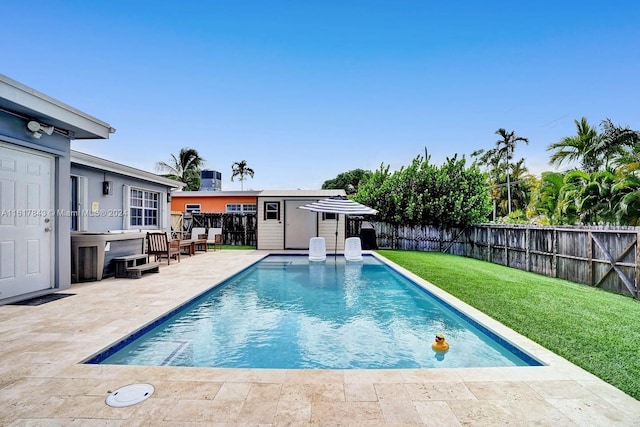 view of swimming pool with an outdoor structure, a patio area, and a lawn