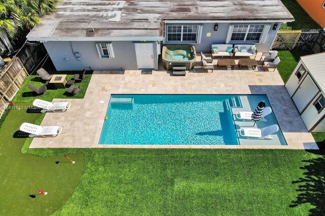 rear view of house featuring an outdoor living space, a patio area, and a fenced in pool