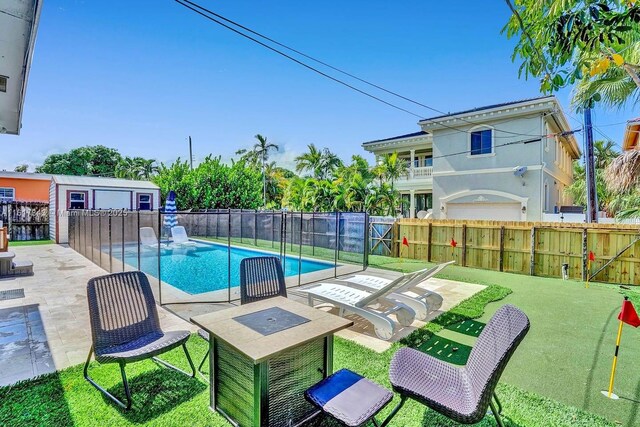 view of pool with a patio and a lawn