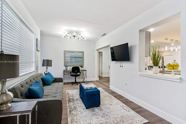 living room with an inviting chandelier and hardwood / wood-style floors