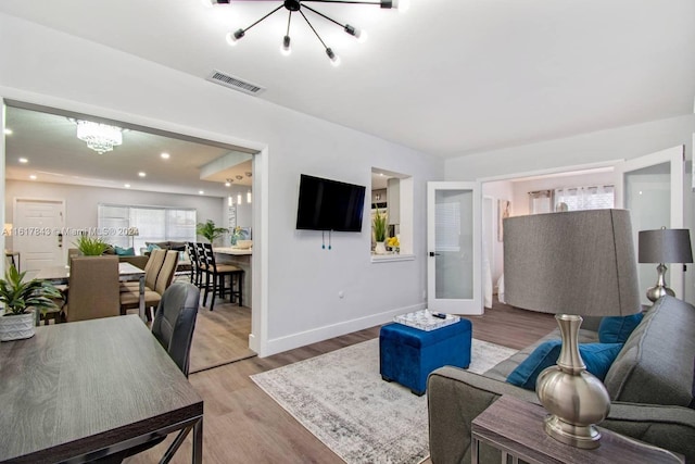 living room with wood-type flooring and a notable chandelier