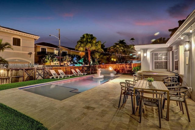 pool at dusk featuring a patio area