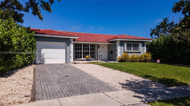 view of front of home with a garage and a front lawn