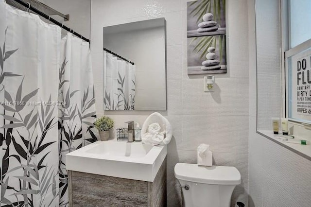 bathroom featuring toilet, vanity, and a shower with curtain