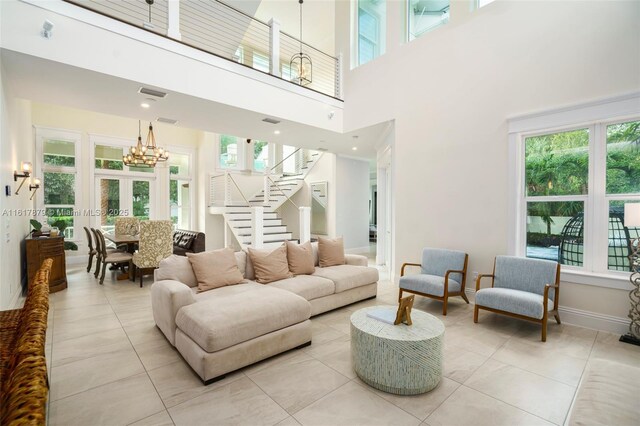 living room featuring light tile patterned flooring, a high ceiling, and an inviting chandelier