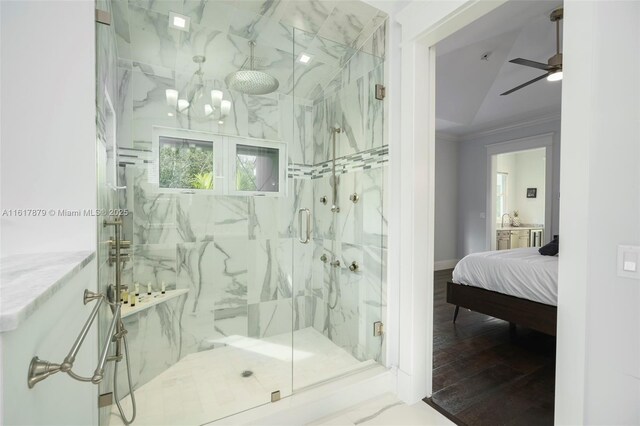 bathroom featuring ceiling fan, wood-type flooring, a shower with shower door, and ornamental molding