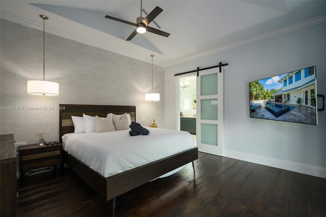 bedroom with a barn door, ceiling fan, hardwood / wood-style floors, vaulted ceiling, and ensuite bath