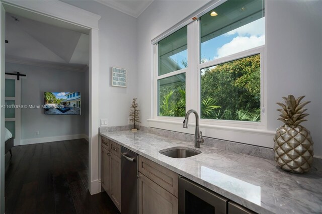 kitchen featuring stainless steel dishwasher, sink, a barn door, light stone countertops, and dark wood-type flooring