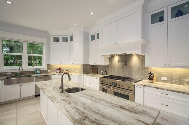 kitchen with sink, decorative backsplash, appliances with stainless steel finishes, and light tile patterned floors