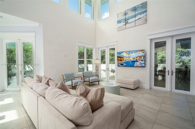 tiled living room with a towering ceiling, plenty of natural light, and french doors