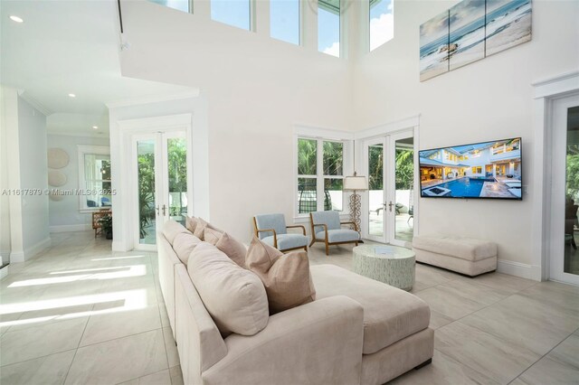 tiled living room featuring a high ceiling and french doors