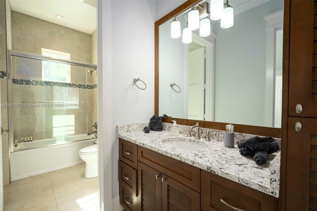 full bathroom with combined bath / shower with glass door, crown molding, tile patterned floors, toilet, and vanity