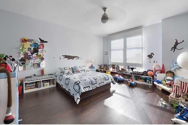 bedroom with dark hardwood / wood-style flooring and ceiling fan