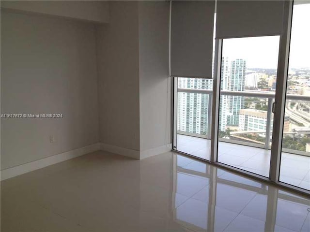 465 Brickell Ave Unit 3706, Miami, FL 33131 - empty room featuring a city view, baseboards, and tile patterned floors