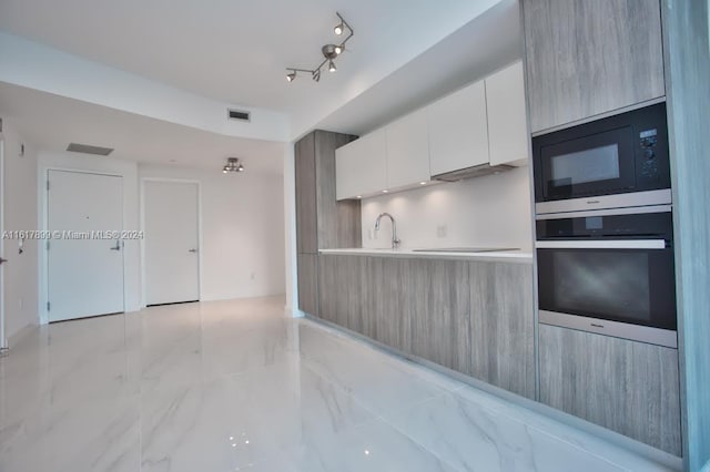 kitchen featuring white cabinets, sink, oven, and black microwave