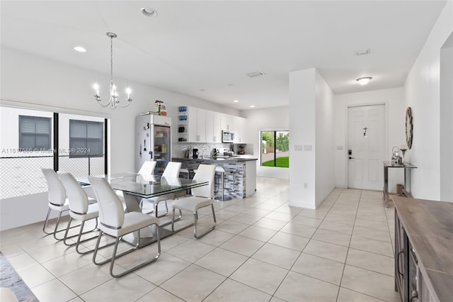 tiled dining room featuring a notable chandelier