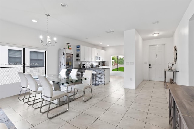 tiled dining room with a chandelier