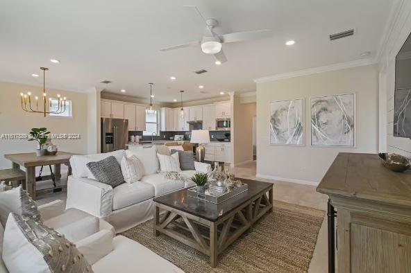 living room featuring ceiling fan with notable chandelier and ornamental molding