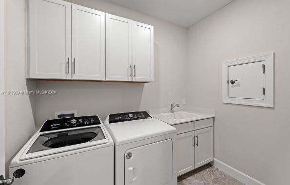 laundry room featuring cabinets, sink, light tile patterned flooring, and washer and dryer