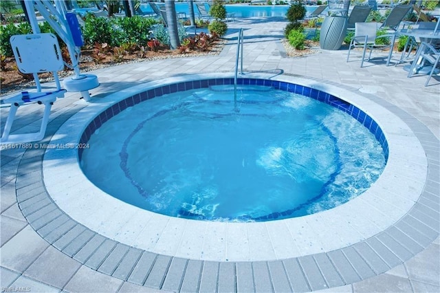 view of pool featuring a patio area and a hot tub